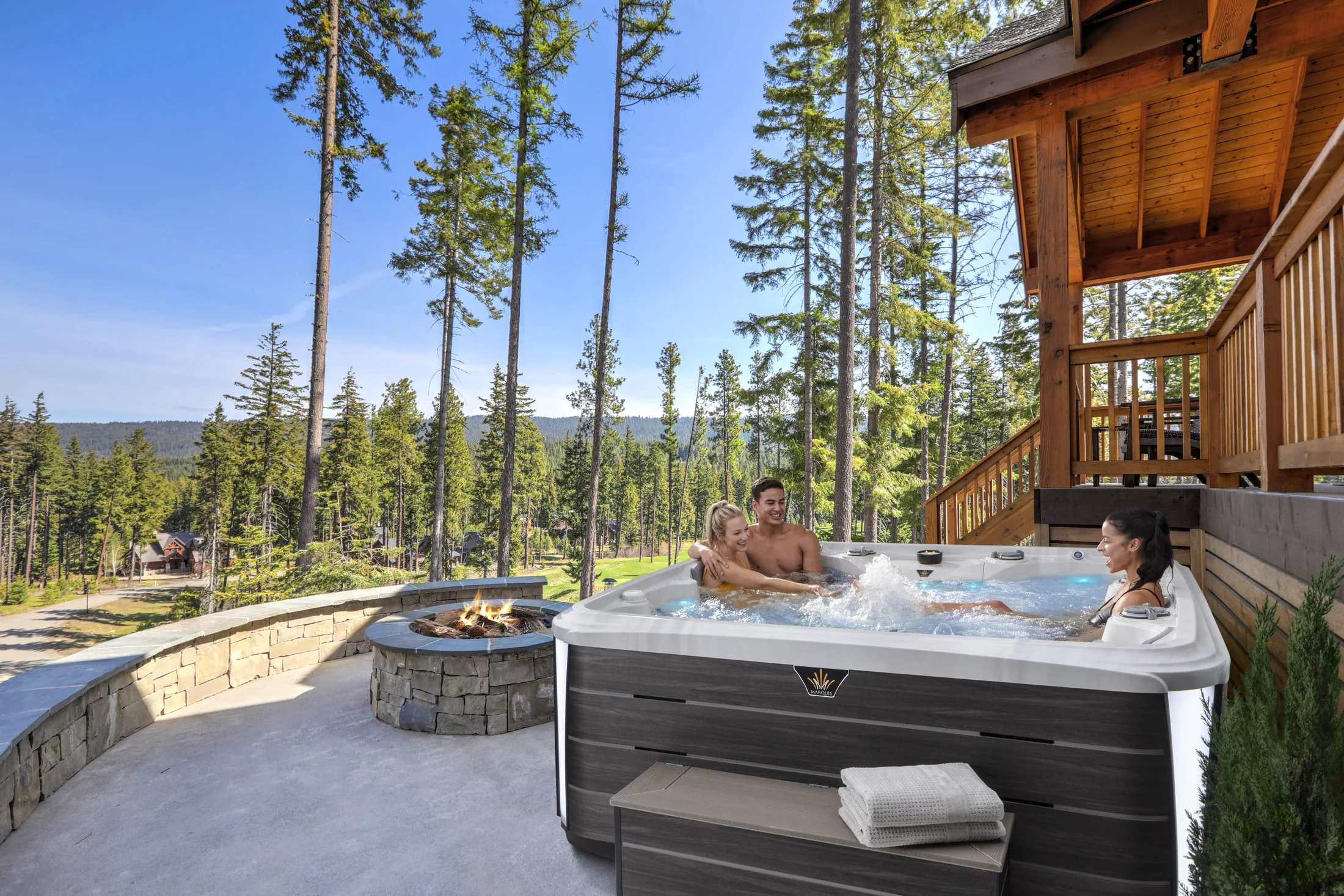 Hot tub beside a timber home in a wooded setting