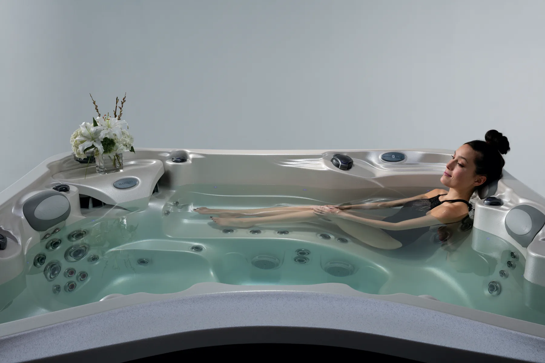 Seats and jets inside a filled hot tub